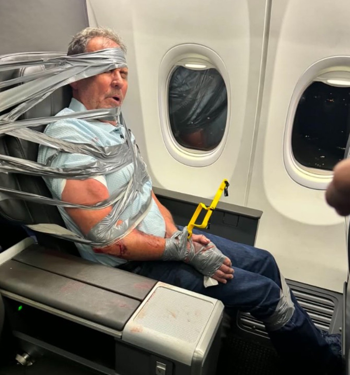 Homem amarrado à poltrona de avião durante voo da American Airlines