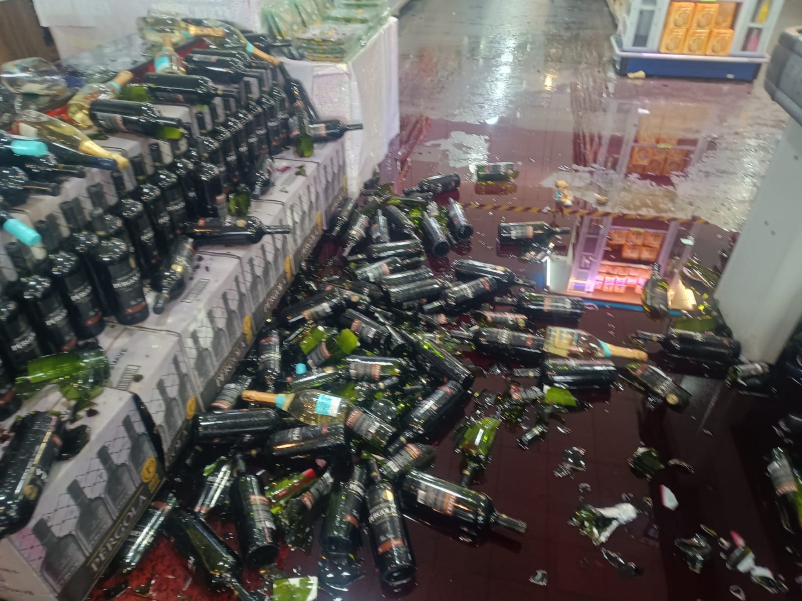 Garrafas de vinho quebradas no chão de supermercado