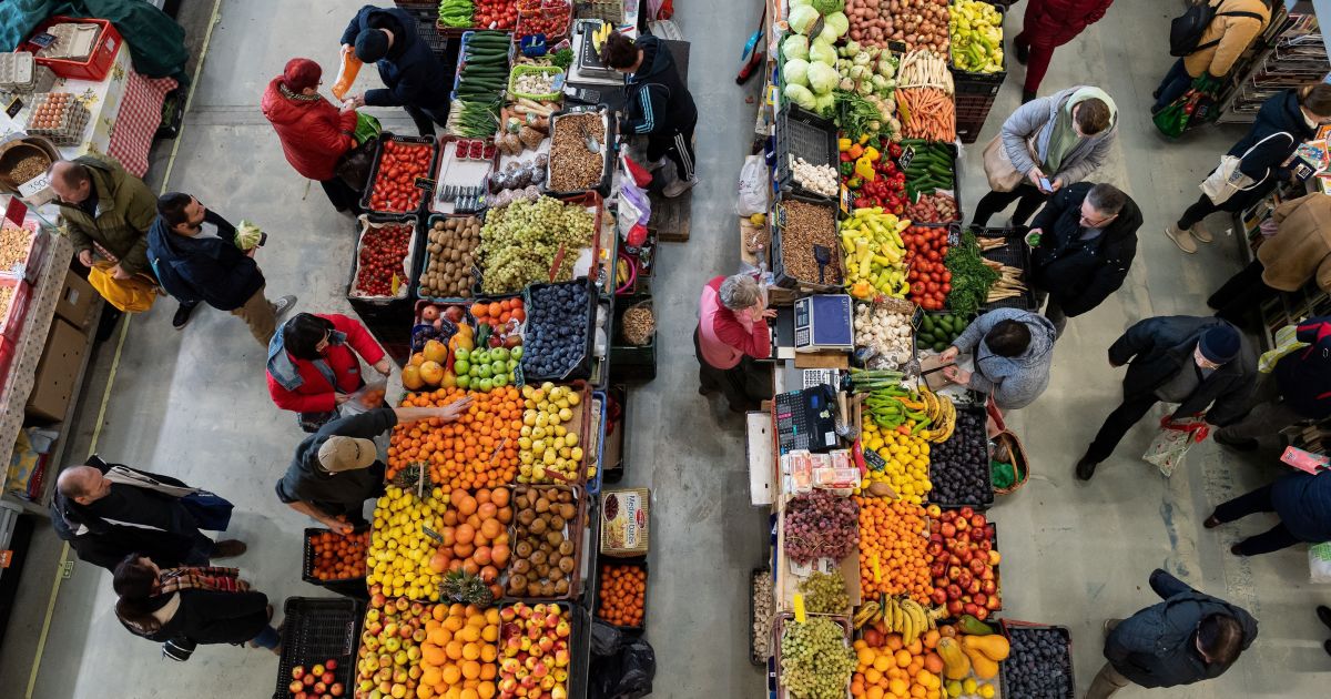 Pessoas compram frutas em mercado