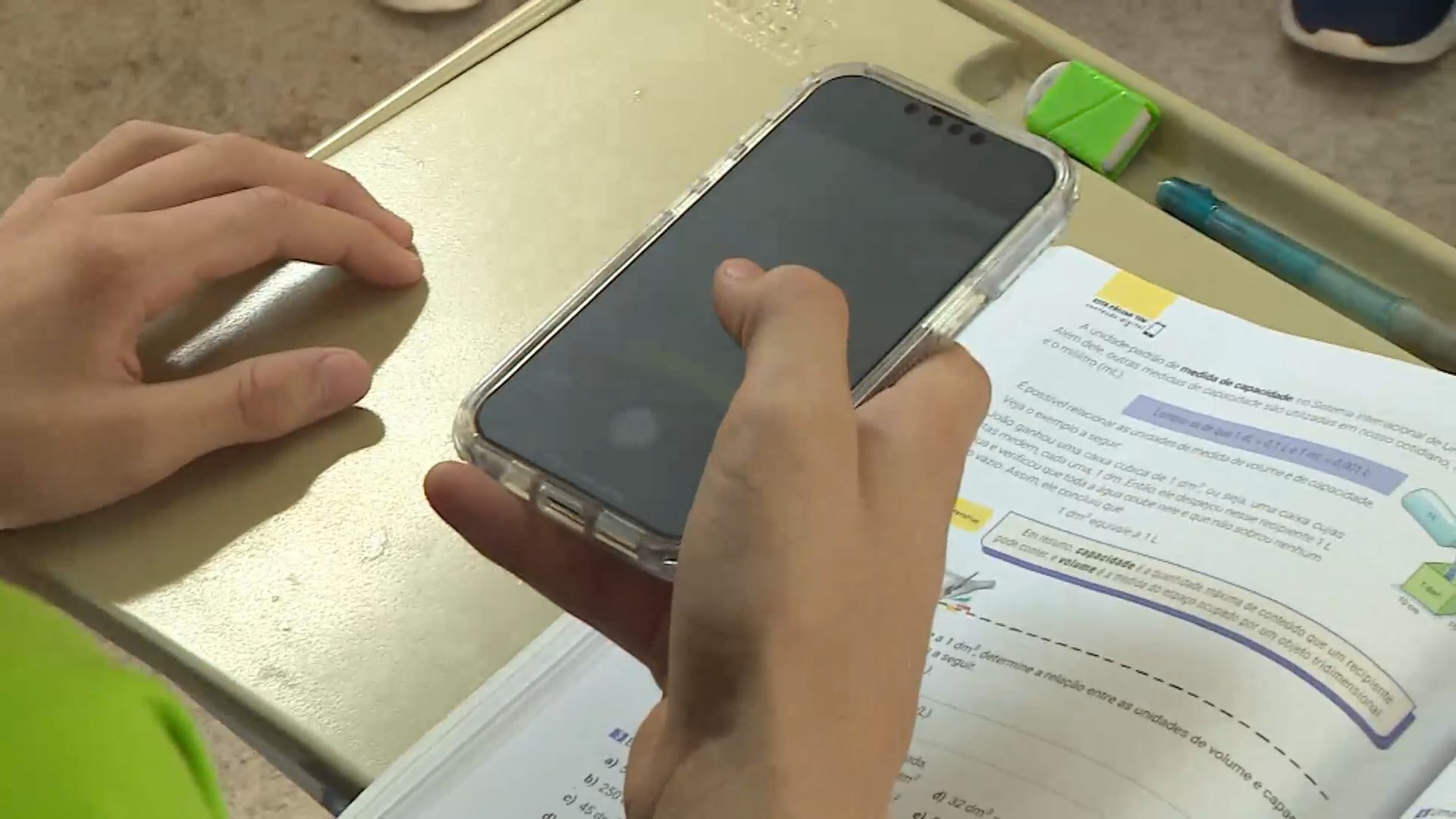 Aluno usa celular durante aula em sala de escola