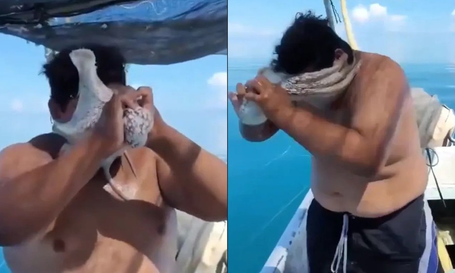 Pescador tenta retirar polvo preso ao rosto em embarcação