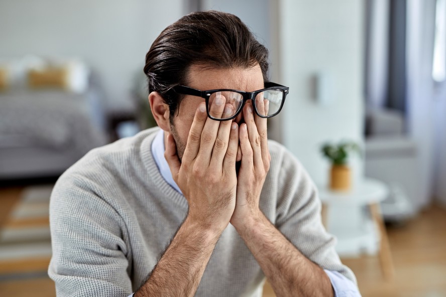 Homem com expressão de mal-estar após consumir álcool