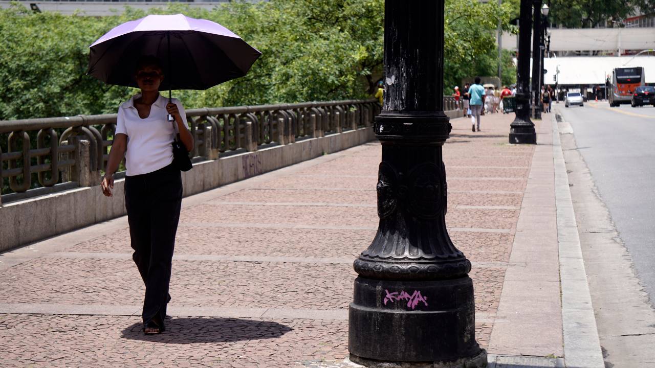 Pessoa se protege do calor no centro de São Paulo