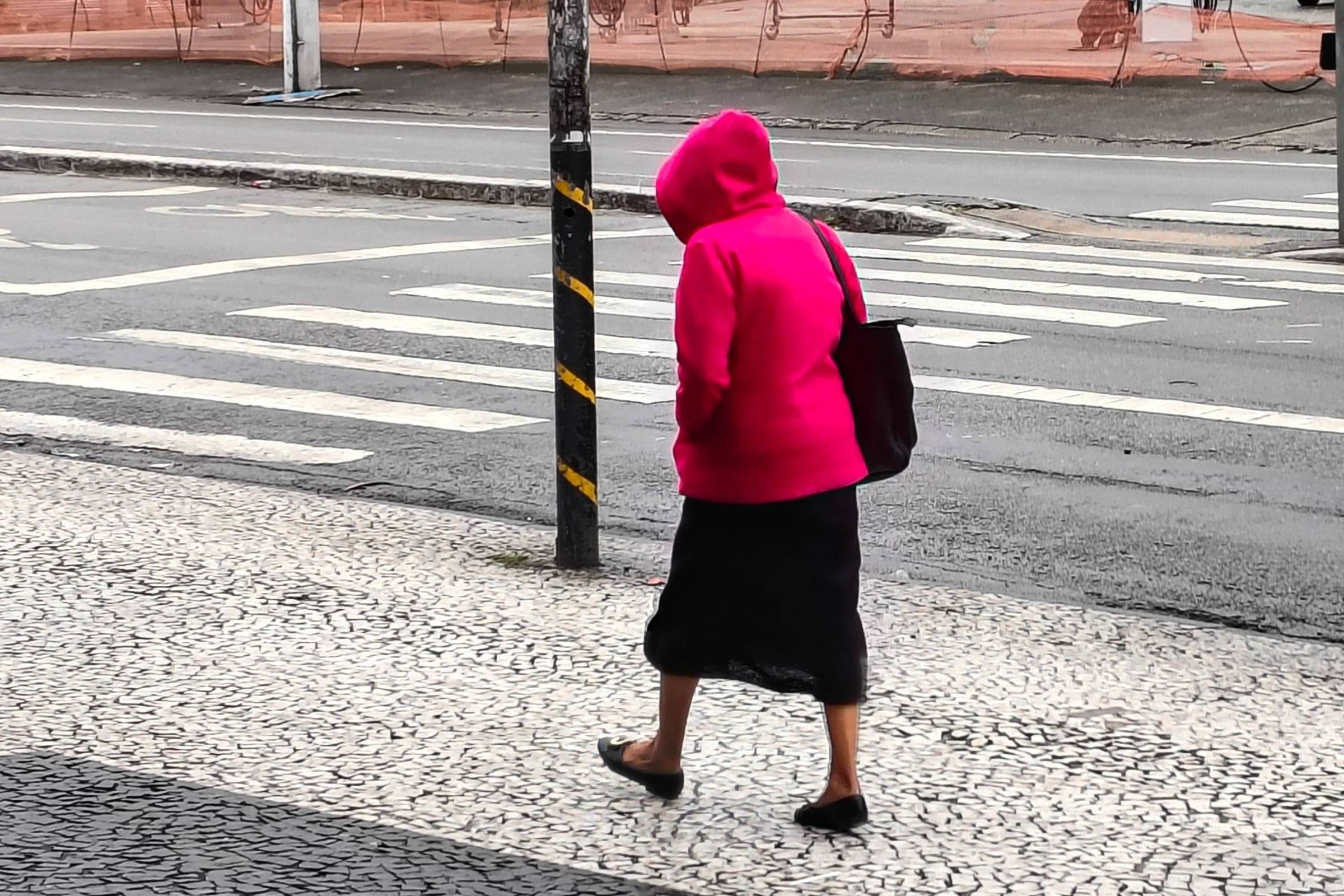 Pedestres caminham com roupas de frio na Avenida Interlagos, em São Paulo