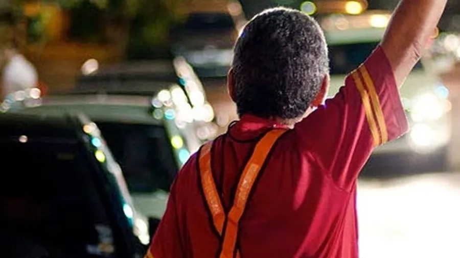 Flanelinha em rua com carros estacionados