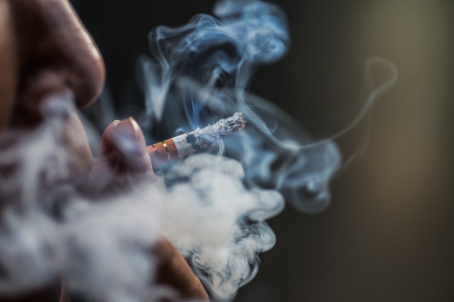 Cigarro aceso com fumaça