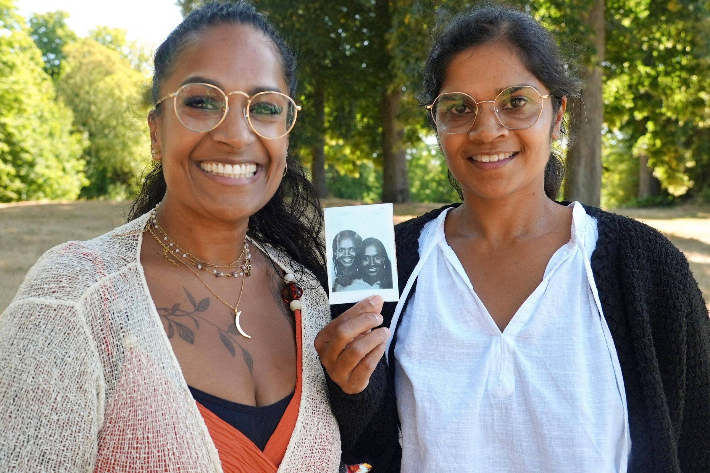 Meena Geltink e Minal Tijssen em parque, segurando uma fotografia antiga