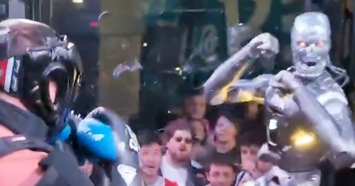 Frankie Lapenna e robô humanoide frente a frente em ringue de boxe
