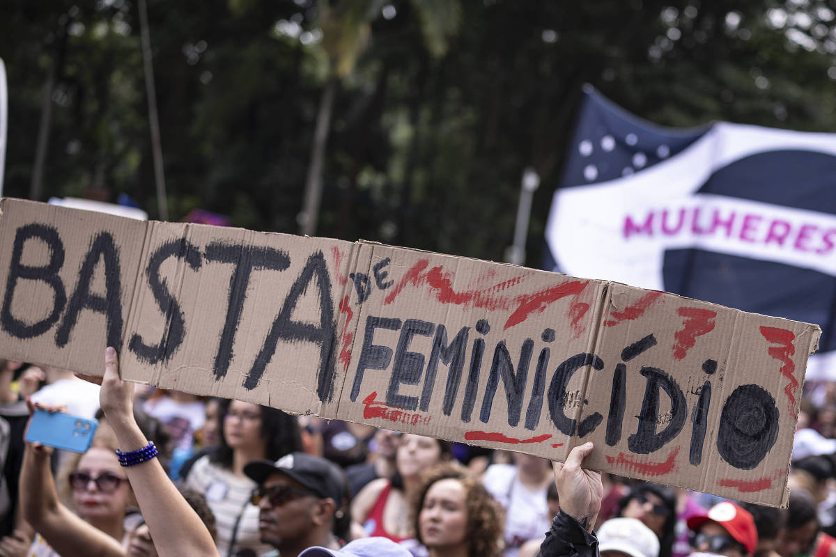 Manifestante segura cartaz com a frase Basta de Feminicídio durante protesto