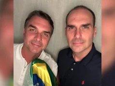 Flávio Bolsonaro, à esquerda, com uma bandeira do Brasil, e Eduardo Bolsonaro, nos Estados Unidos