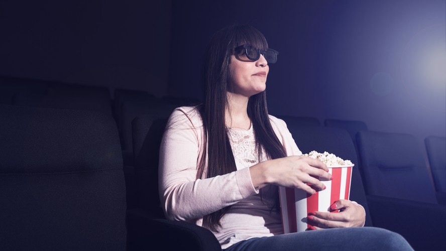 Mulher sentada em uma sala de cinema