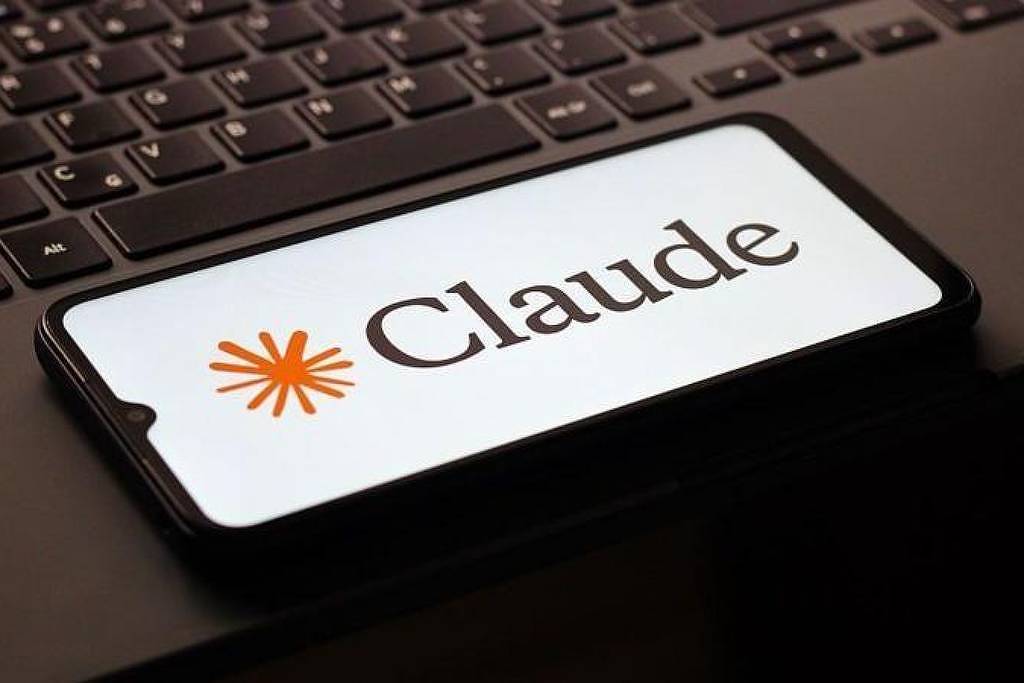 Celular exibe o logotipo do Claude sobre teclado de laptop
