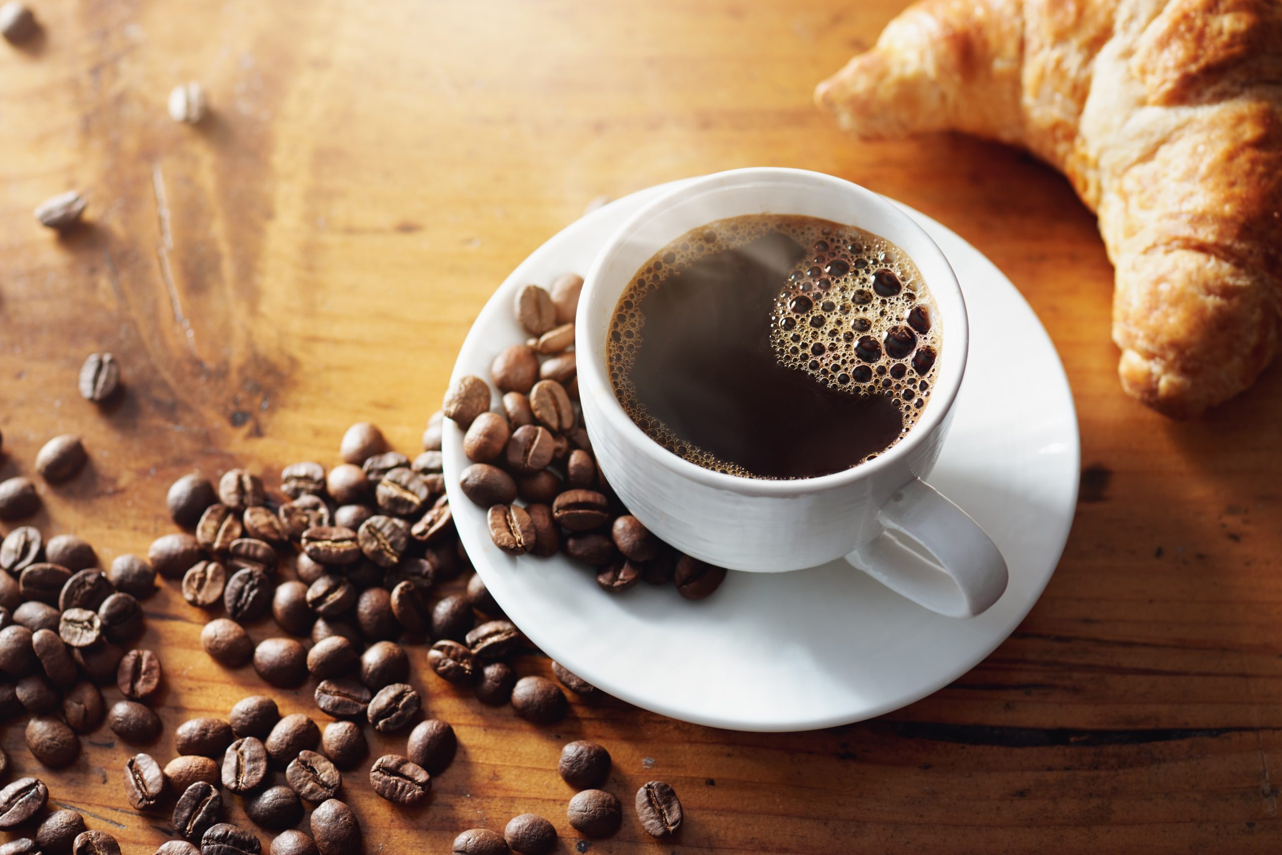 Xícara de café coado ao lado de grãos de café