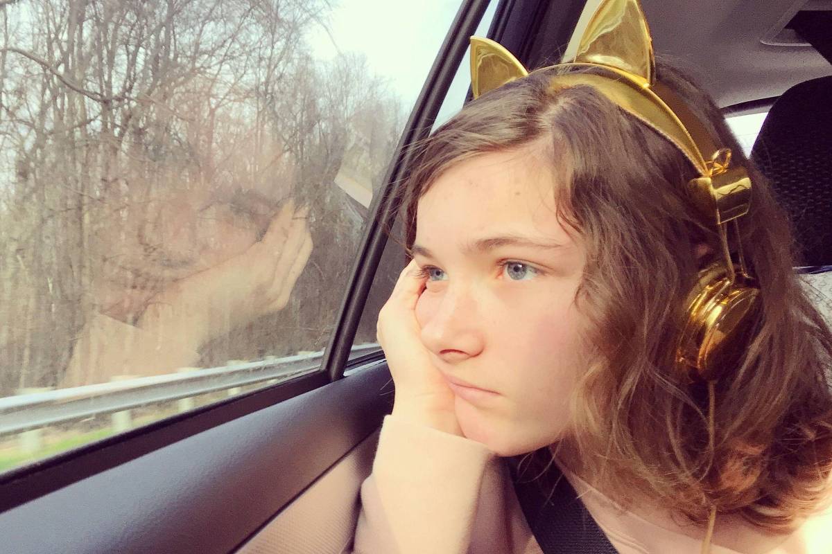 Mulher olha pela janela durante viagem de carro