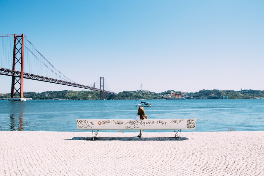 Mulher sentada às margens do Rio Tejo, em Lisboa