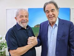 Lula aperta a mão do cineasta Oliver Stone em ambiente interno