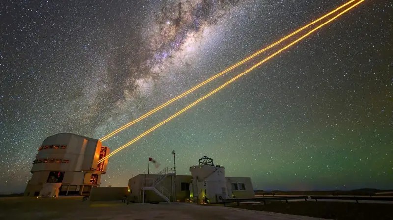 Feixes de laser do Telescópio Muito Grande apontados para o céu noturno no deserto do Atacama