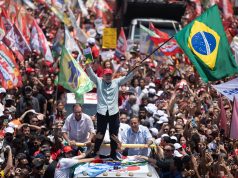 Lula em veículo durante ato de campanha com bandeiras do Brasil em Copacabana