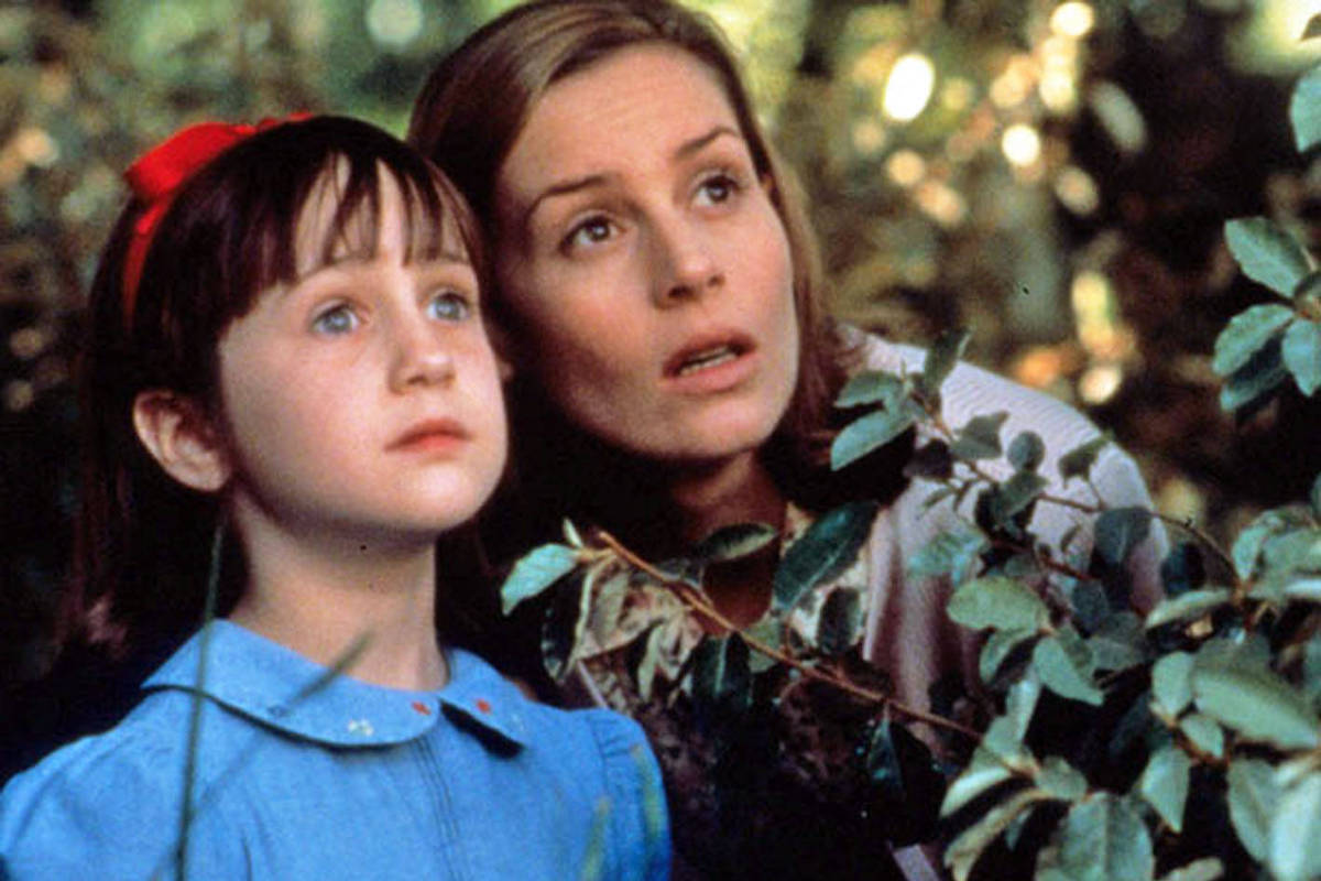 Cena do filme Matilda com personagens diante de folhas verdes