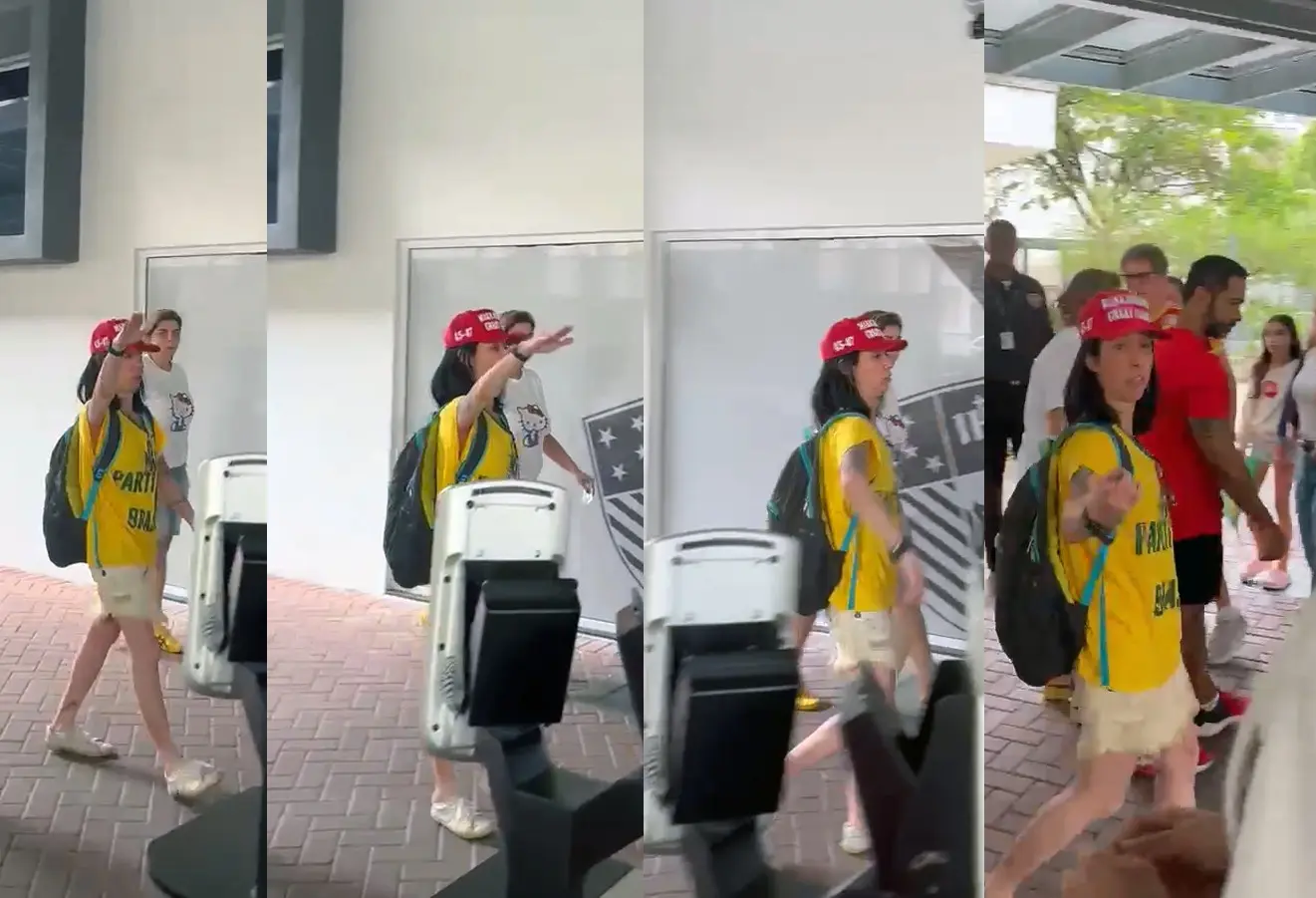 Eleitora de camisa amarela e boné faz gesto com o braço erguido em pátio de escola