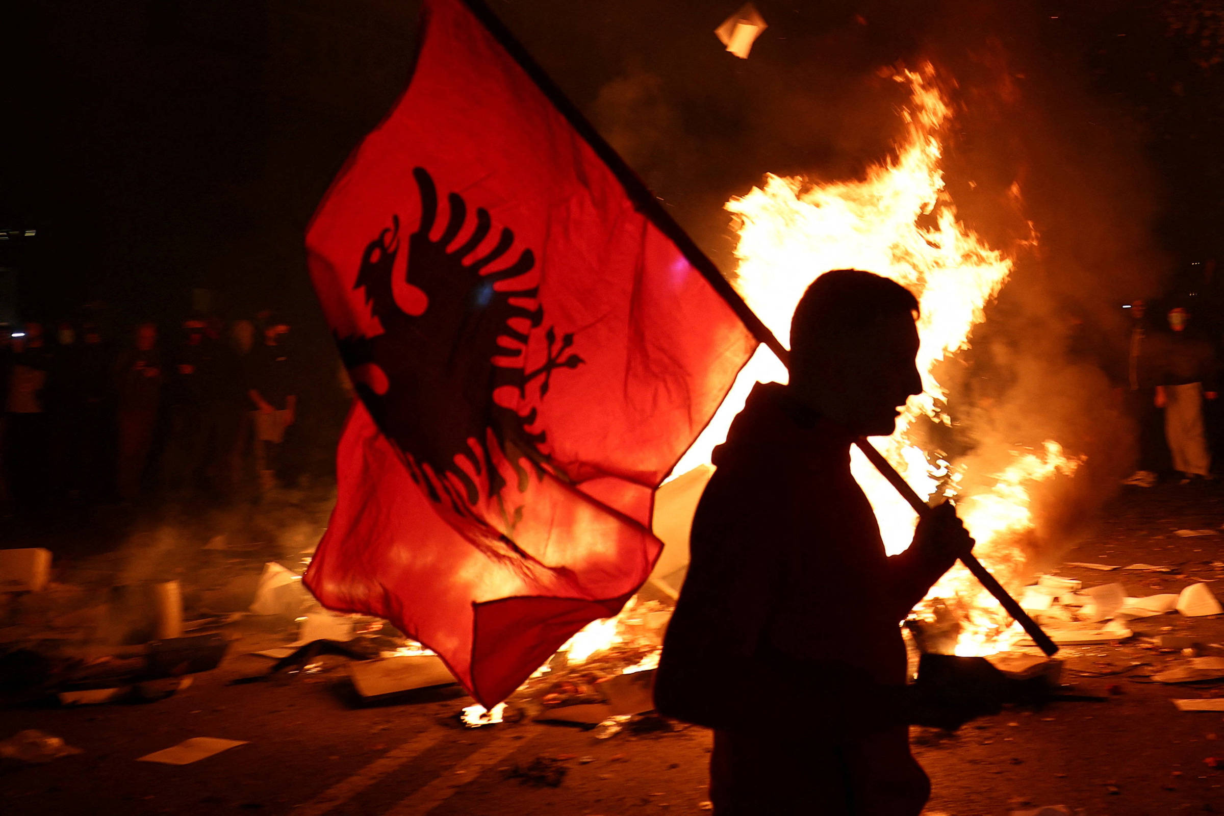 Manifestante segura bandeira da Albânia durante protesto estudantil em Tirana