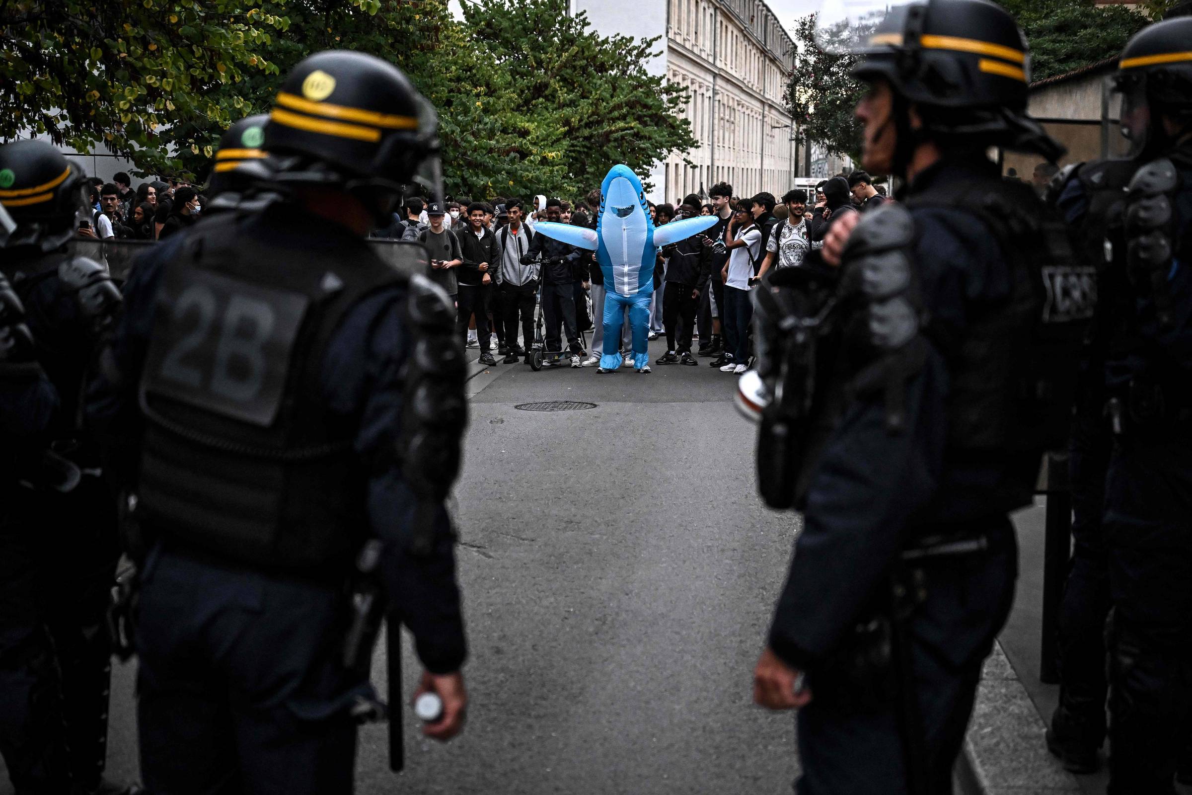 Estudante fantasiado de tubarão diante de policiais em Bordeaux, na França