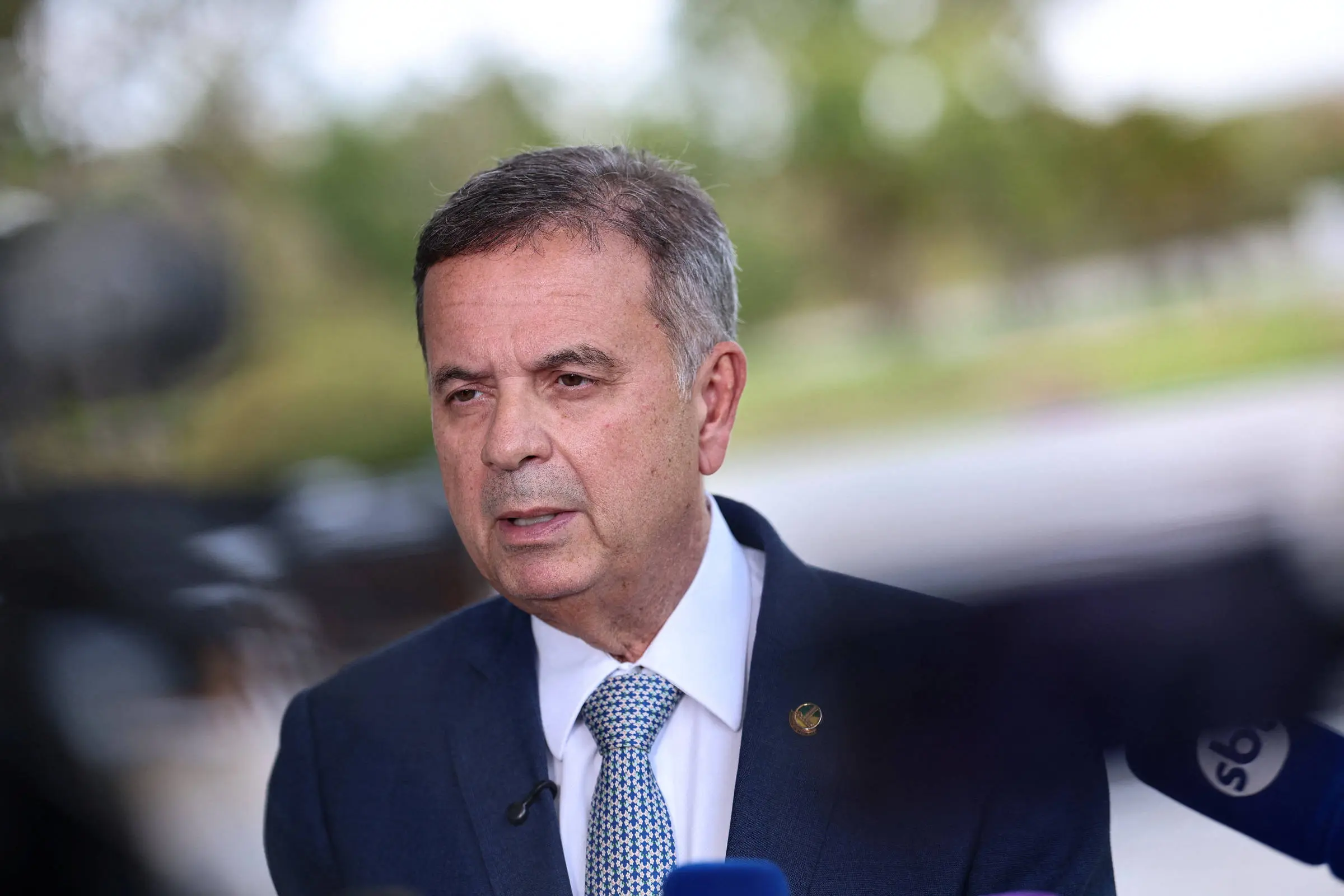 Rogério Marinho fala a microfones usando terno azul e gravata clara