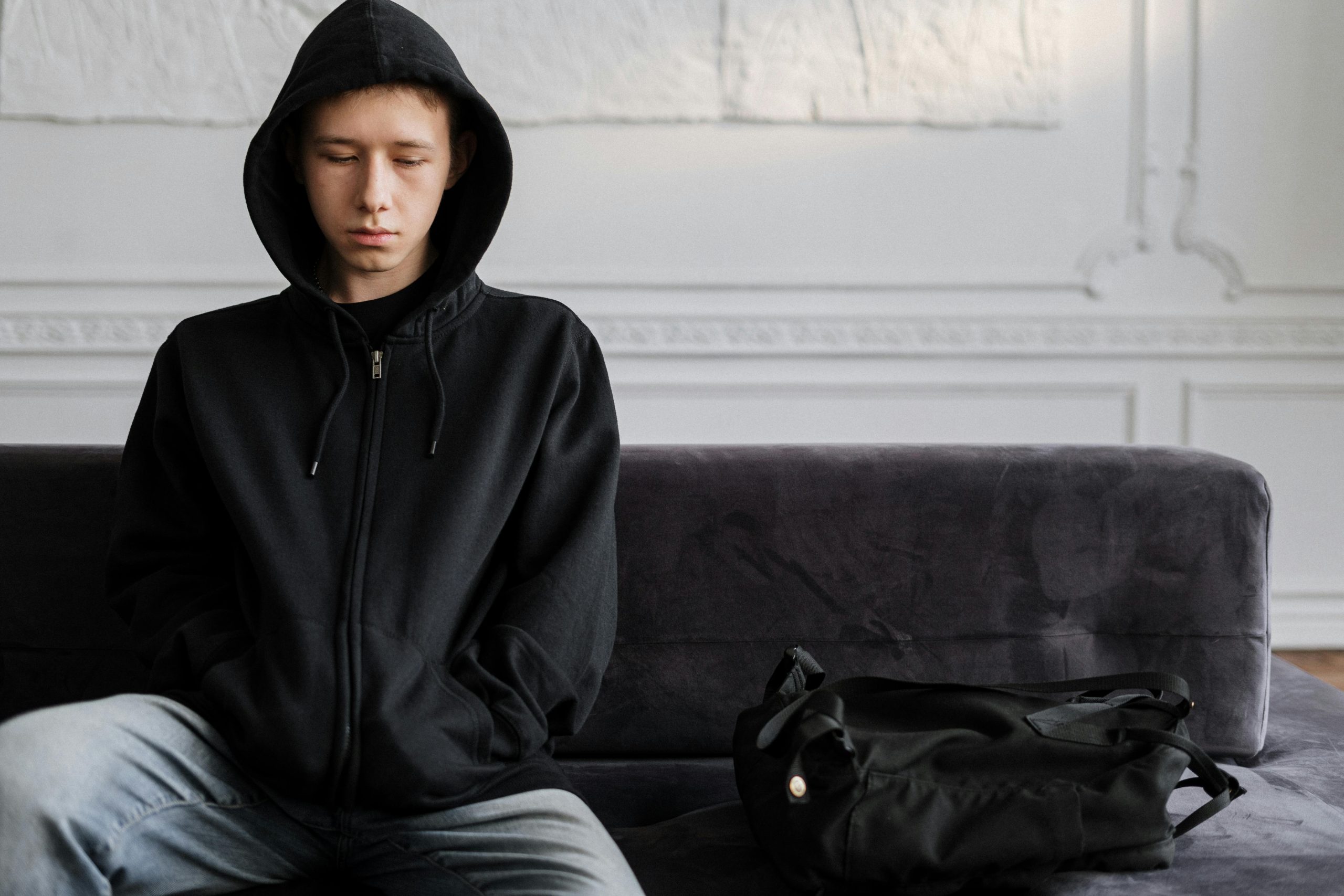 Adolescente sentado com expressão triste