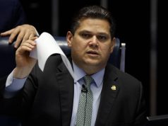 Davi Alcolumbre sentado com uma folha de papel nas mãos