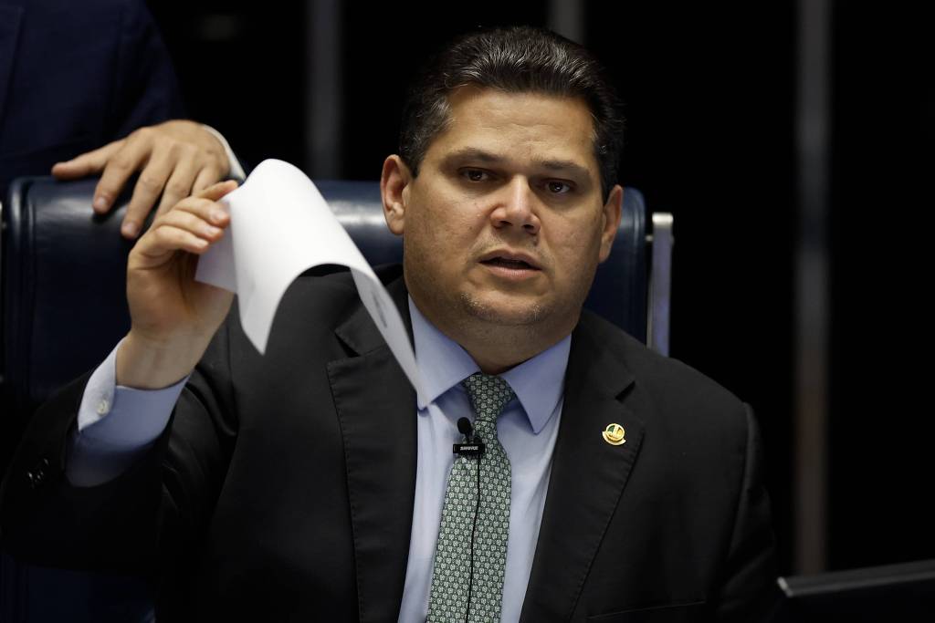 Davi Alcolumbre sentado com uma folha de papel nas mãos