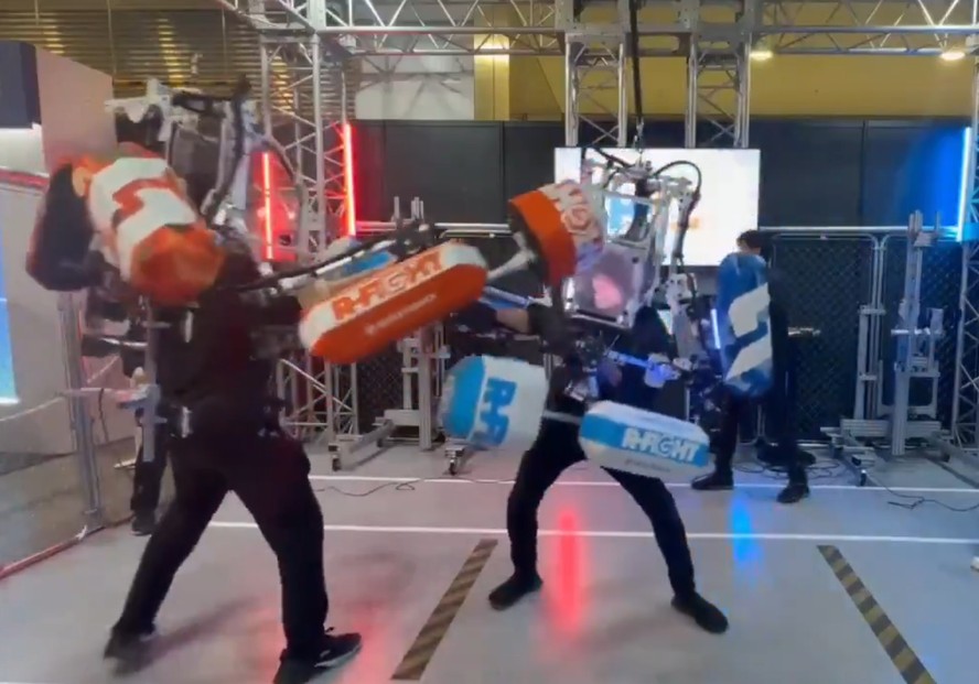 Dois robôs gigantes controlados por participantes durante combate