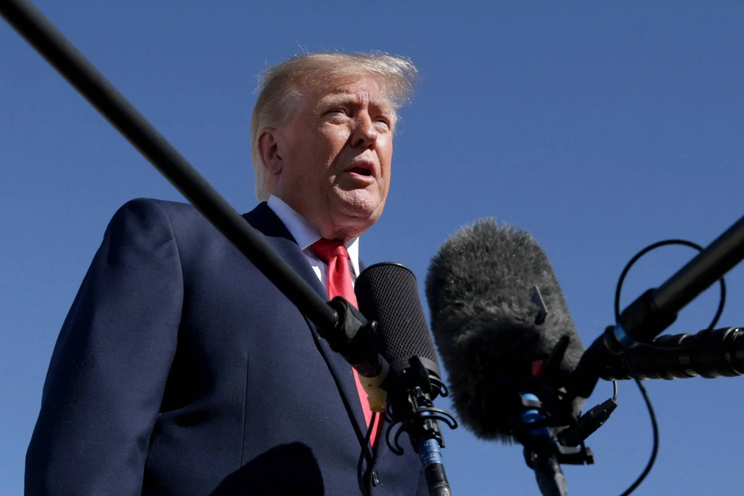 Donald Trump fala a jornalistas diante de microfones