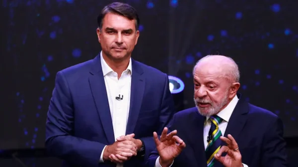 Flávio Bolsonaro atrás de Lula durante debate da Band